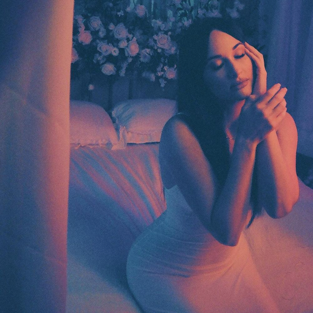 Kacey Musgraves sitting on the bed in recording studio